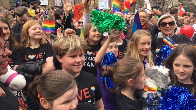 Children wave colourful streamers at a rally for marriage equality in Melbourne.
