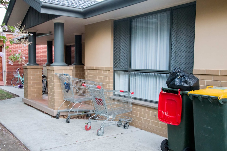 Two shopping trolleys out the front of a house