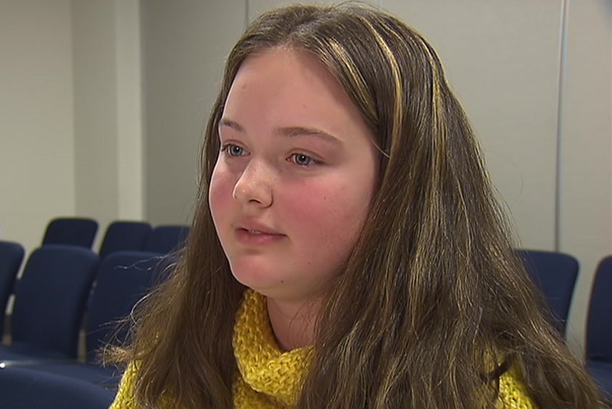 Anika Floris sits at a table.