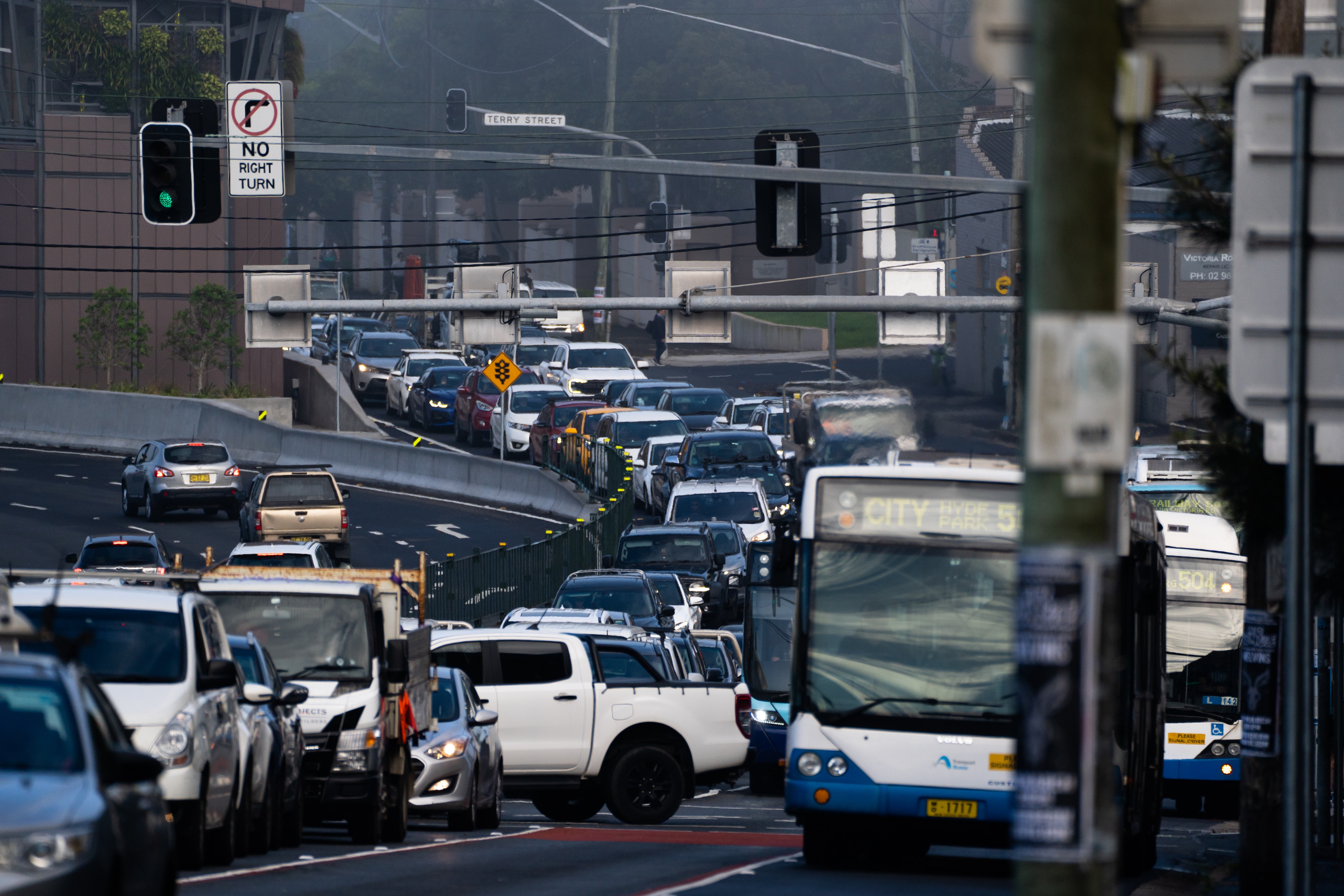 Image shows congestion and traffic delays. You can see cars, grey road on a gloomy day.