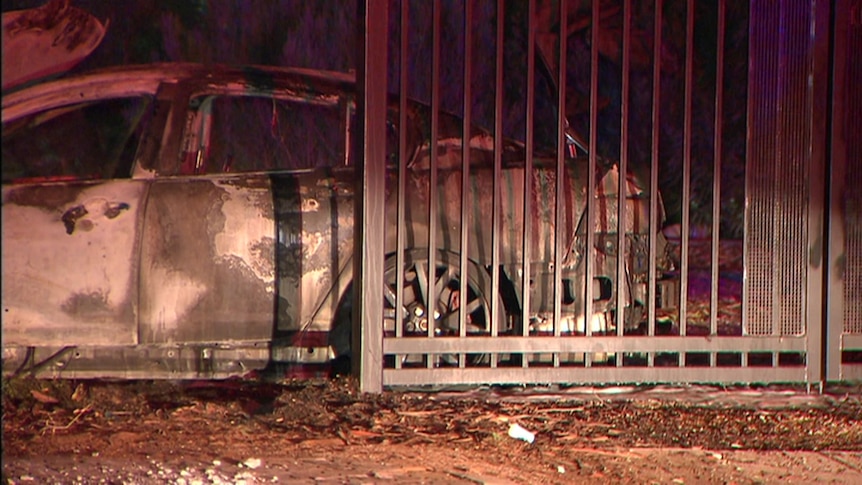 The gutted wreck of a car destroyed by fire.