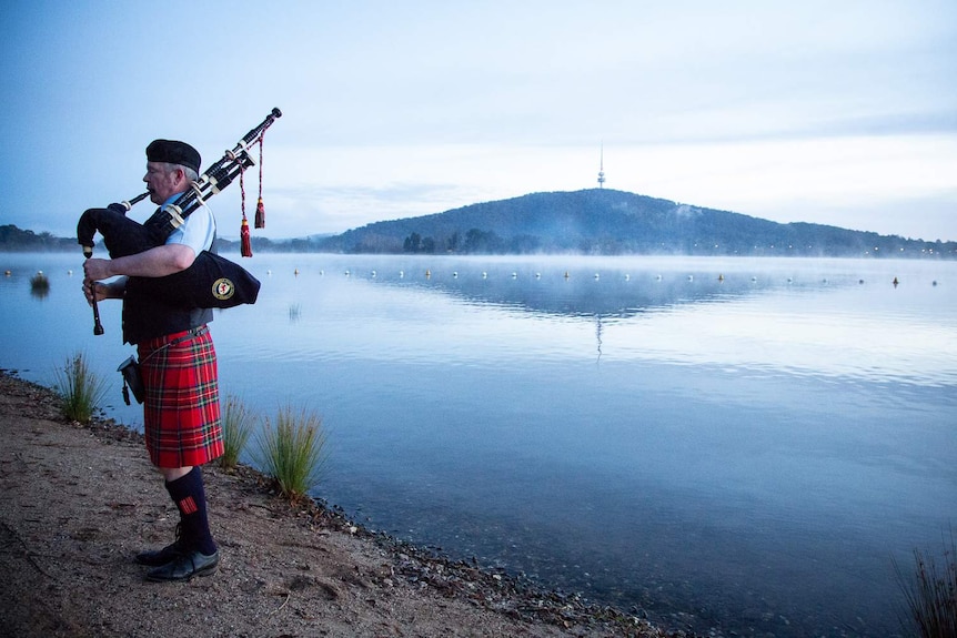 Bag piper plays the pipes beside Lake Burley Griffin