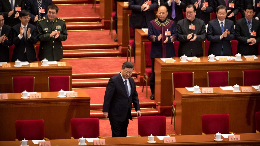 Chinese President Xi Jinping arrives for the closing session of China's parliamentary advisory body. They are applauding him.