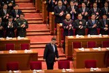 Chinese President Xi Jinping arrives for the closing session of China's parliamentary advisory body. They are applauding him.