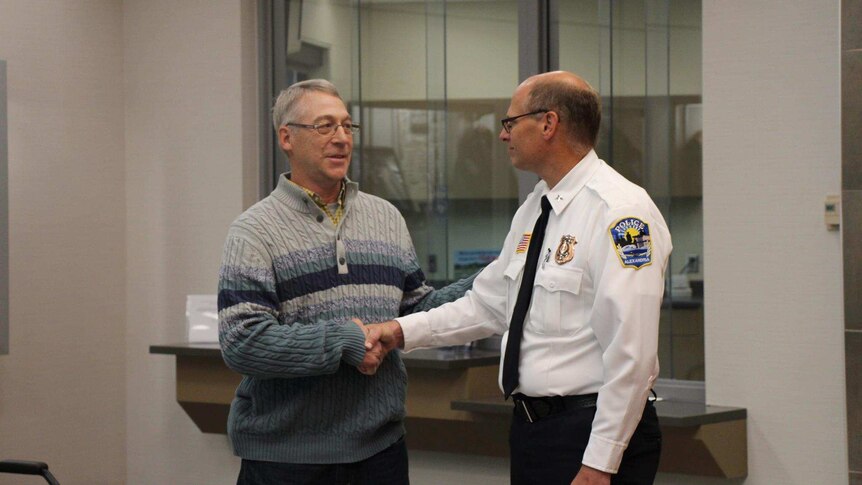 Earl Melchert shakes hands with Alexandria Police Chief Rick Wyffels.