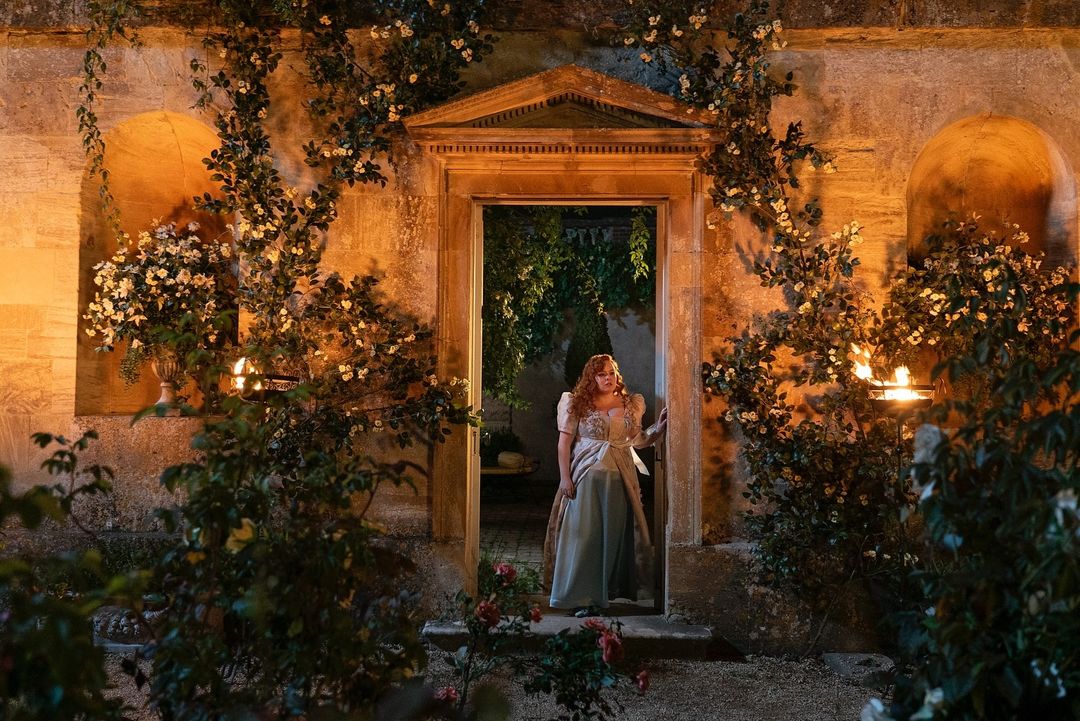A still of the show with the character Penelope in a walled garden 