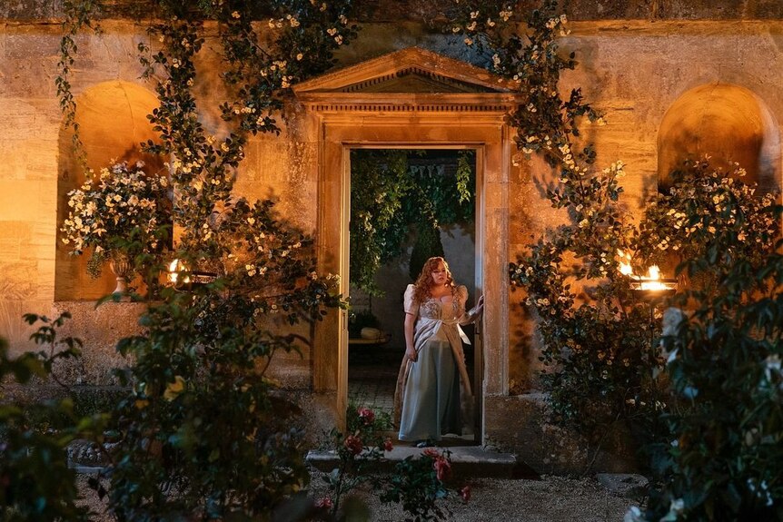 A still of the show with the character Penelope in a walled garden 