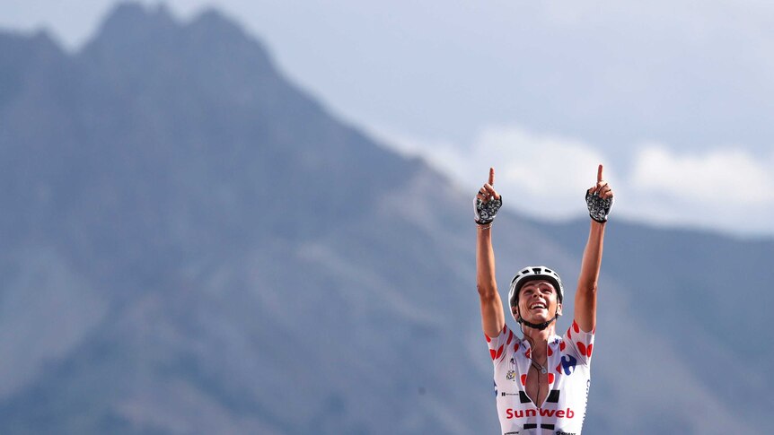France's Warren Barguil, wearing the best climber's dotted jersey celebrates as he crosses the finish line to win the eighteenth stage of the Tour de France