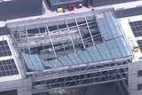 An aerial shot of a glass roof caved in.