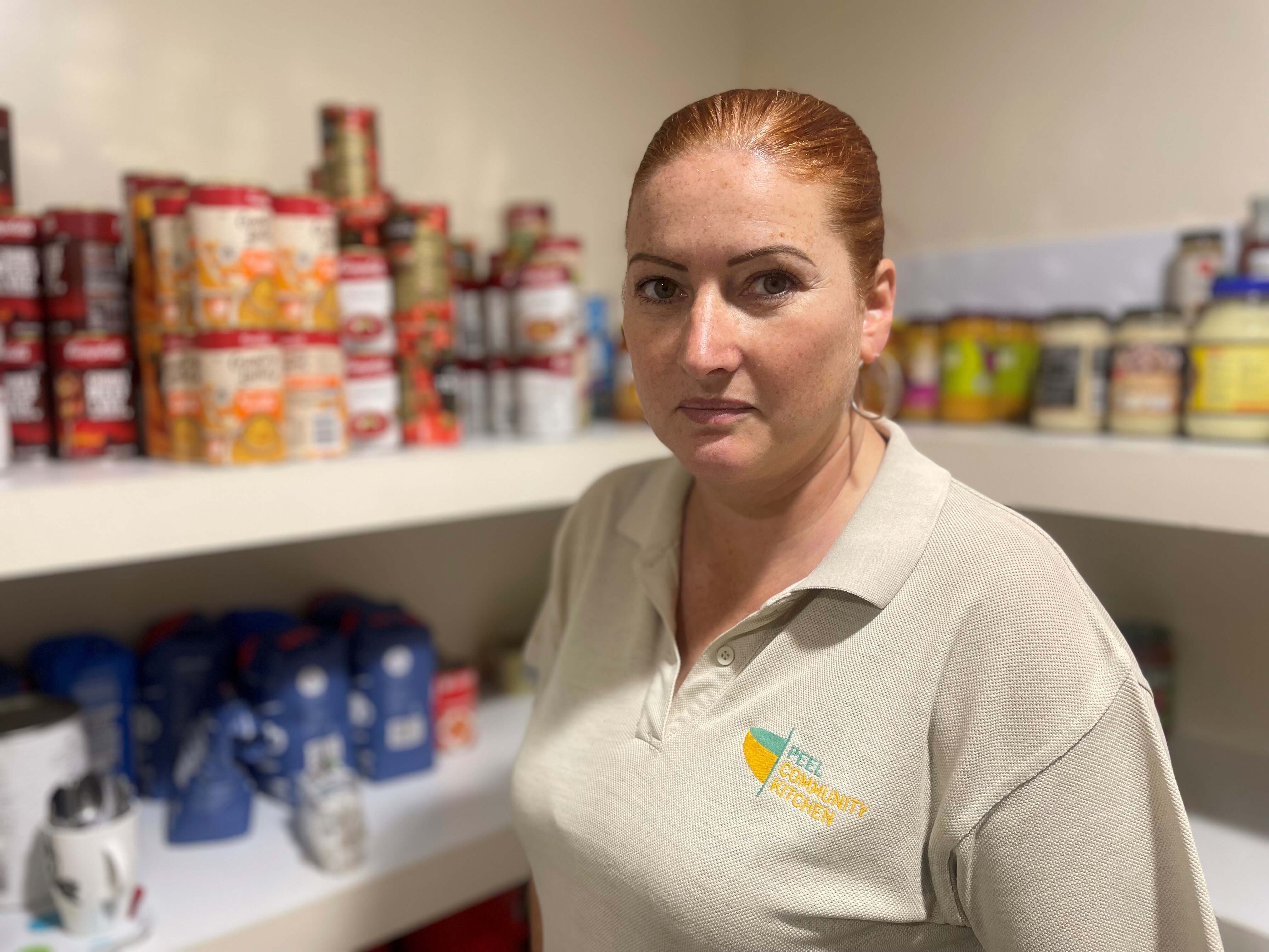 A woman surrounded by shelves with food.