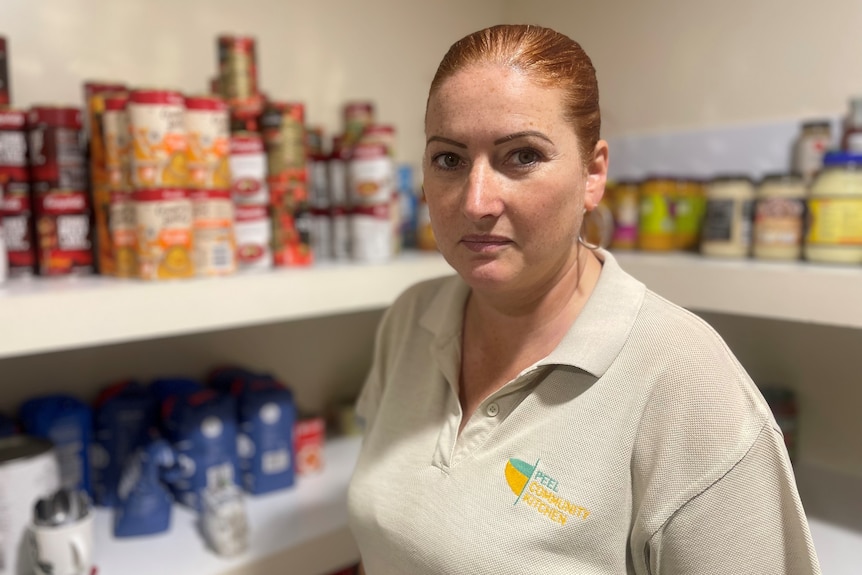 A woman surrounded by shelves with food.