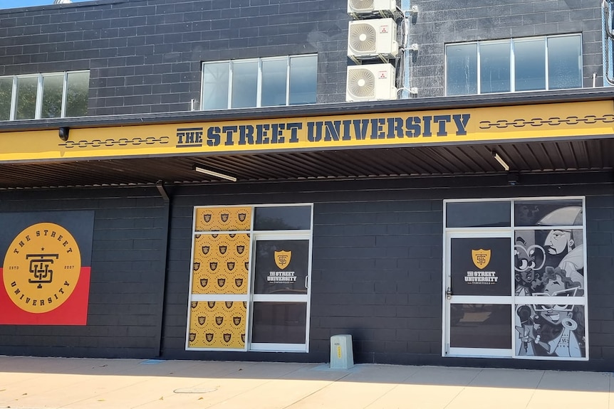 A shop front pained black and yellow, with a bold sign saying "The Street University".