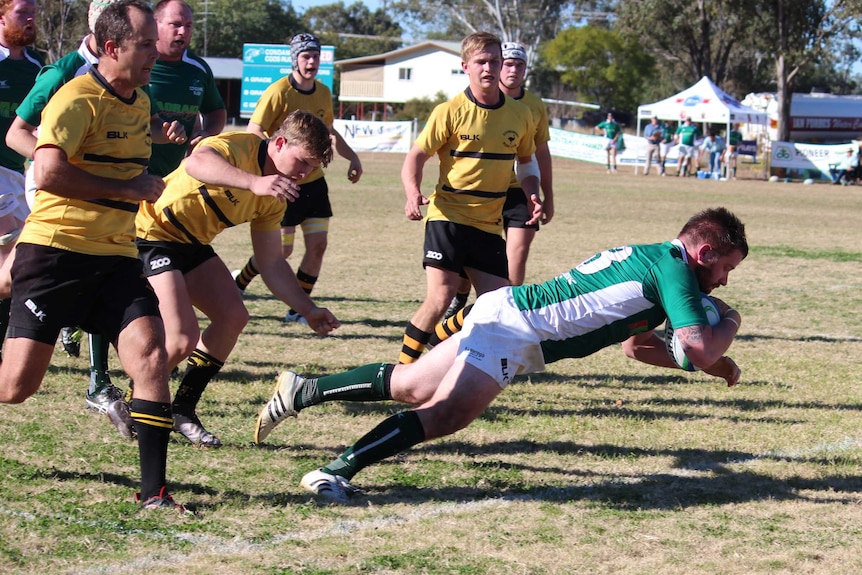 Rugby player Kim McGregor goes over the line for a try.