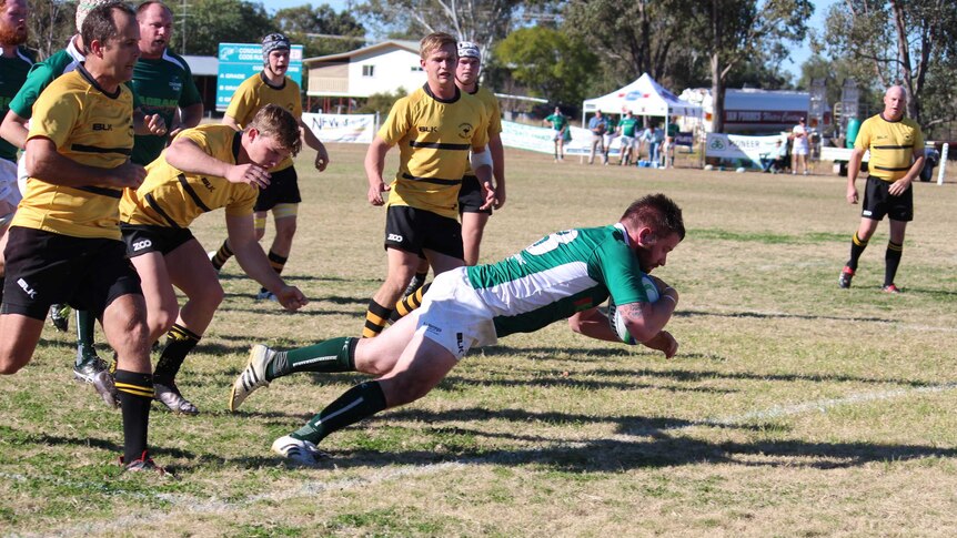 Rugby player Kim McGregor goes over the line for a try.