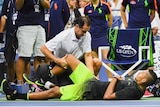 Australia's Nick Kyrgios is examined during his US Open match against Ukraine's Illya Marchenko.
