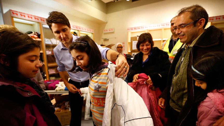 Canada's prime minister helps young Syrian refugee with jacket