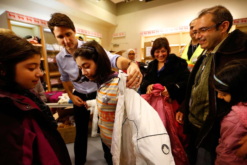 Canada's prime minister helps young Syrian refugee with jacket