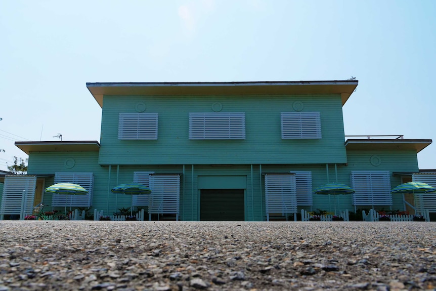 A green, retro-style building for accommodation.