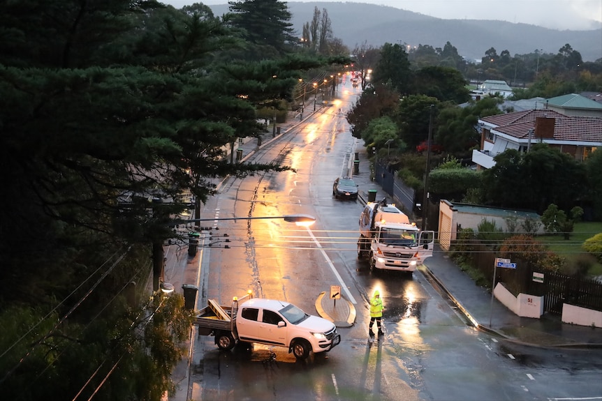 A car parks across the wet street to restrict access.