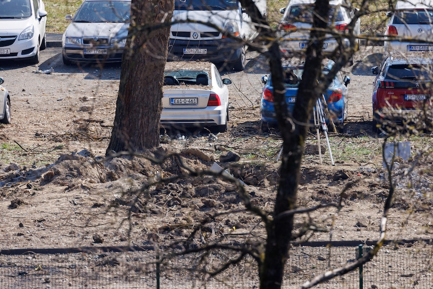 O gaură largă în pământ unde a căzut o dronă.