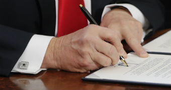 Donald Trump signs an executive order in the Oval Office at the White House