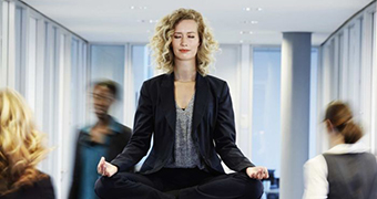 A woman does yoga inside an office.