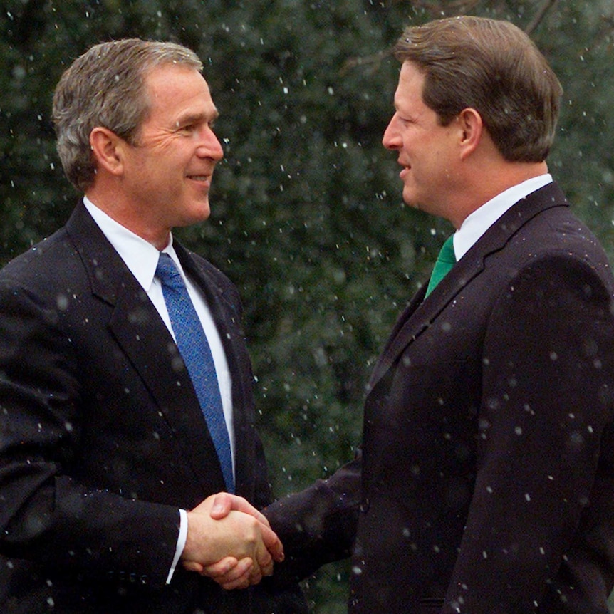 Al Gore shaking hands with George W Bush in the snow