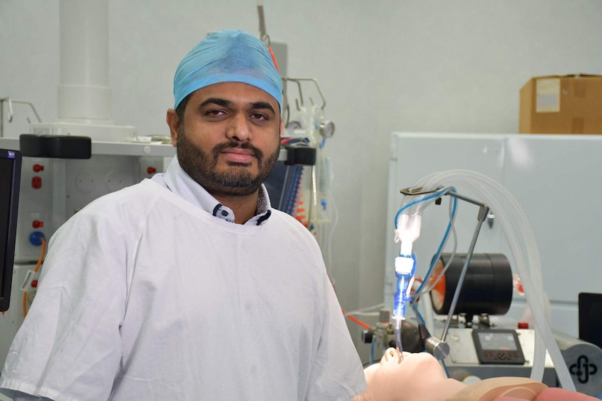 Dr Kiran Shekar stands next to the OzVader ventilator that he helped design.