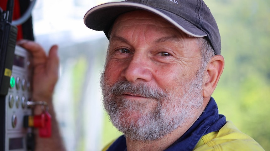 Shot of Spiro Buhagiar smiling at the camera while operating a cable car