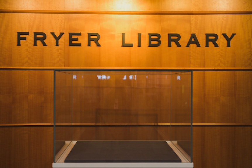 The illuminated sign of the Fryer Library on wood.