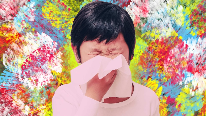 A girl sneezes in front of an abstract burst of colour representing spring flowers.