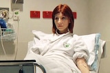 Young woman sits on hospital bed