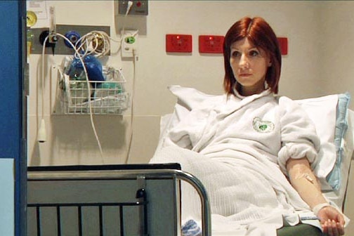 Young woman sits on hospital bed