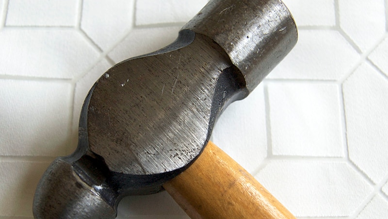 A hammer sits on a bench.