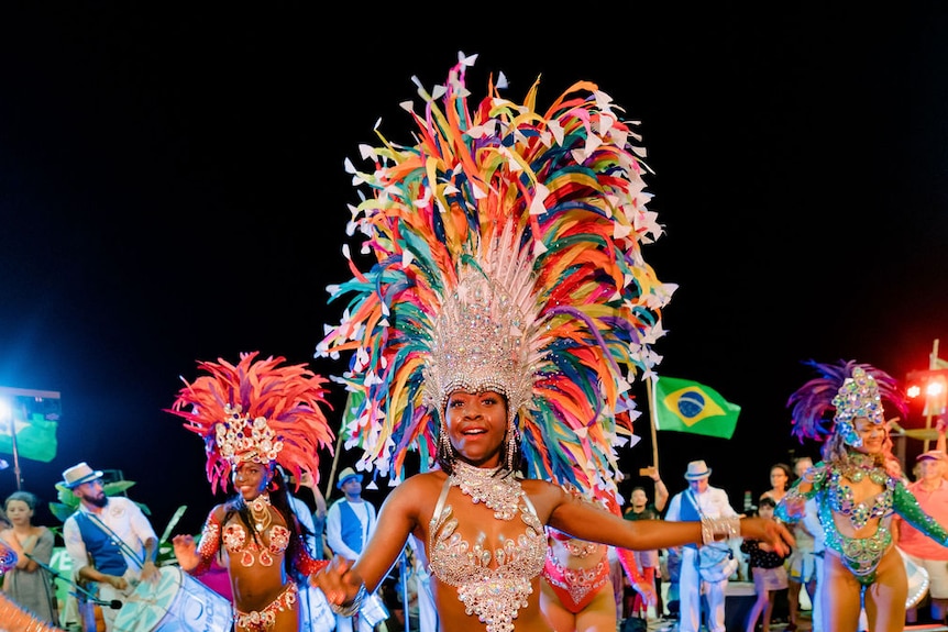 woman dancing in colourful feather headdress 