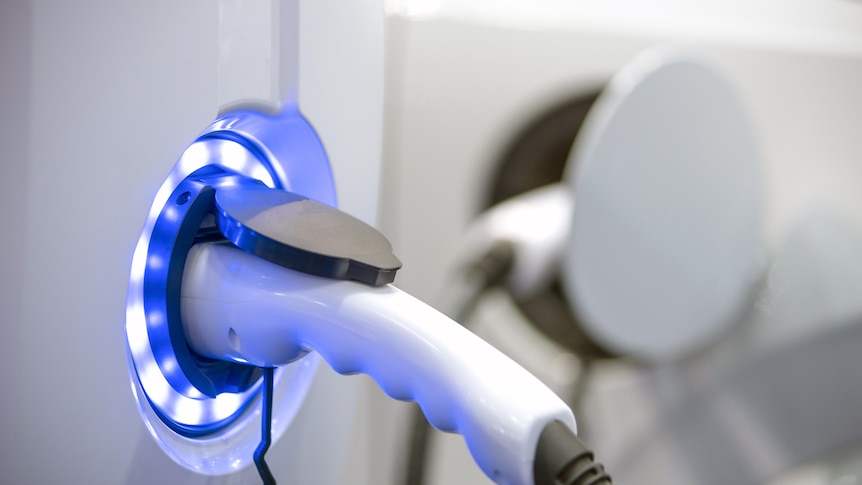 An EV plug surrounded by bright blue LEDs
