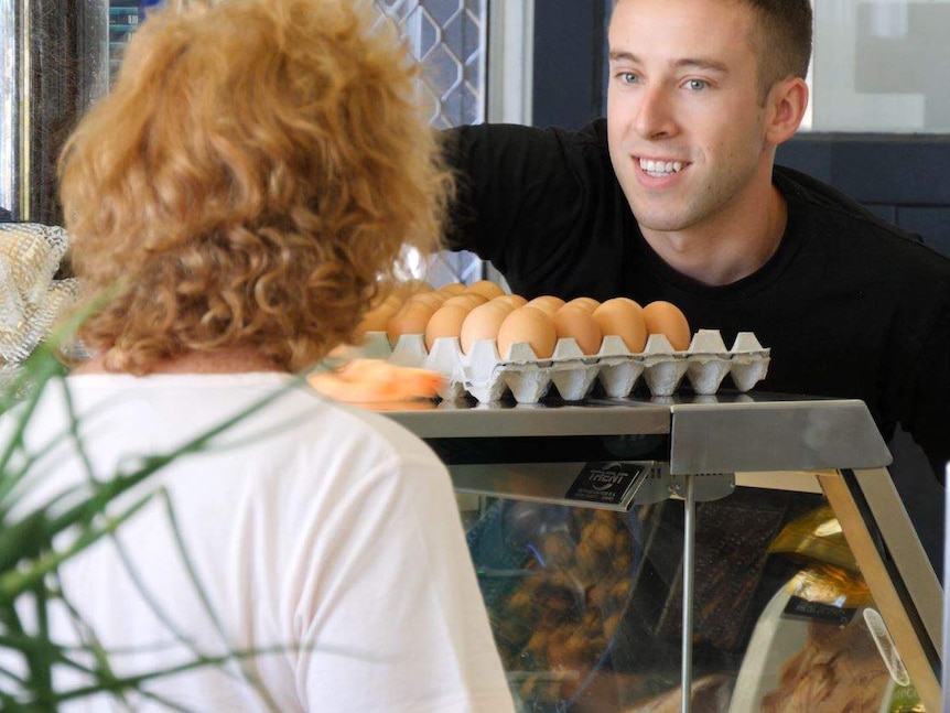 A man serving a customer in a deli