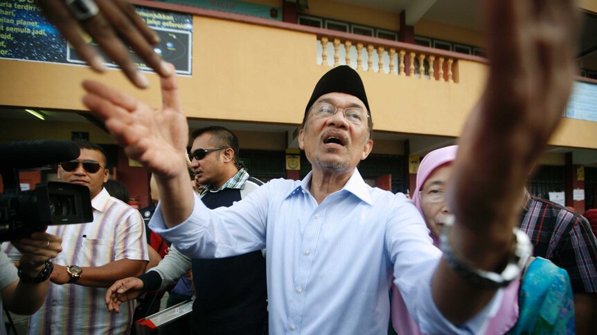 Anwar Ibrahim greets supporters after casting his vote.