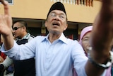 Anwar Ibrahim greets supporters after casting his vote.