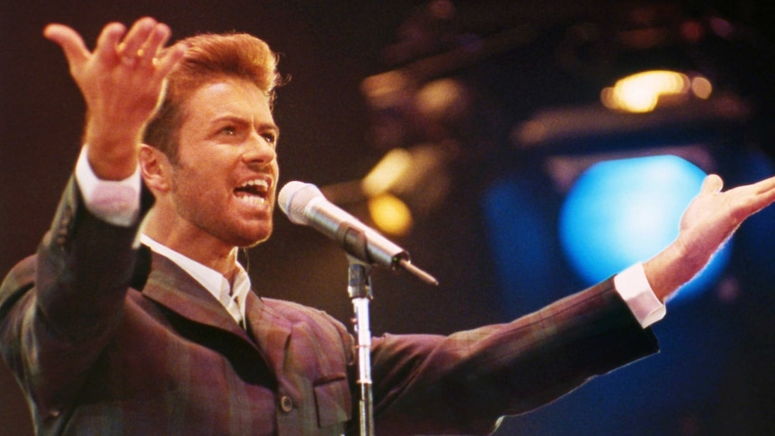George Michael raises his hands as he sings on stage at the Concert of Hope in 1993.