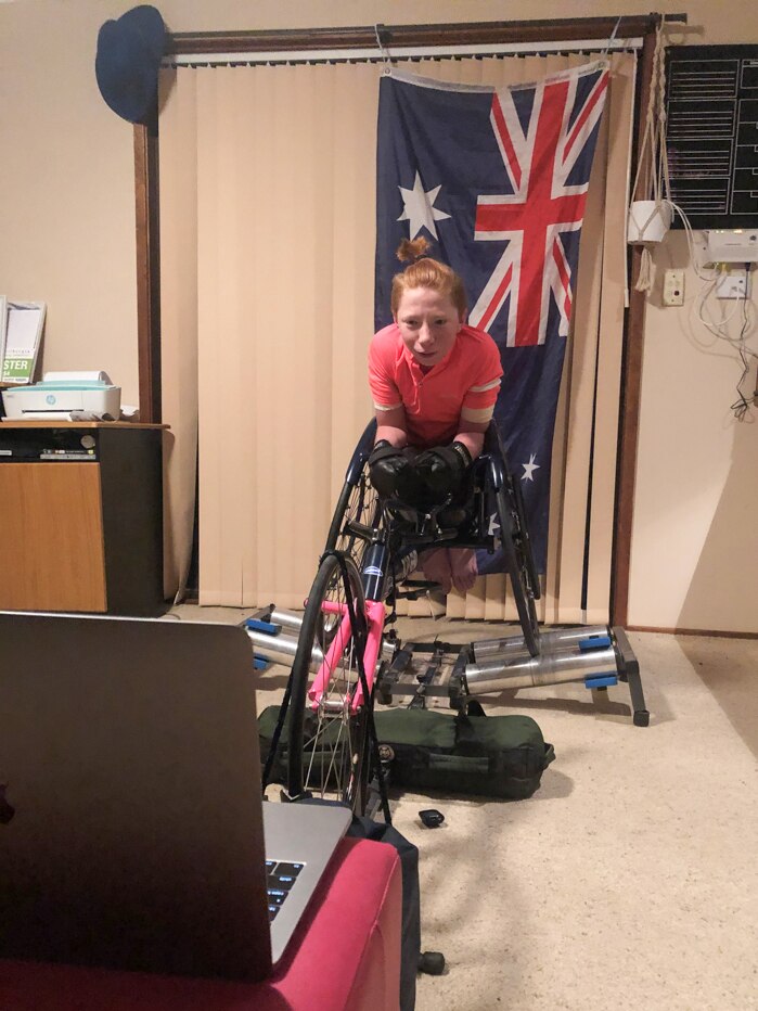 Wheelchair racer Waryk Holmes sitting in front of a laptop computer.