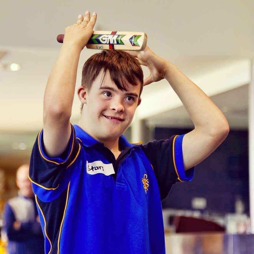 Tim Garrity from St Francis Xavier raises his bat after hitting a 'six' in table cricket.