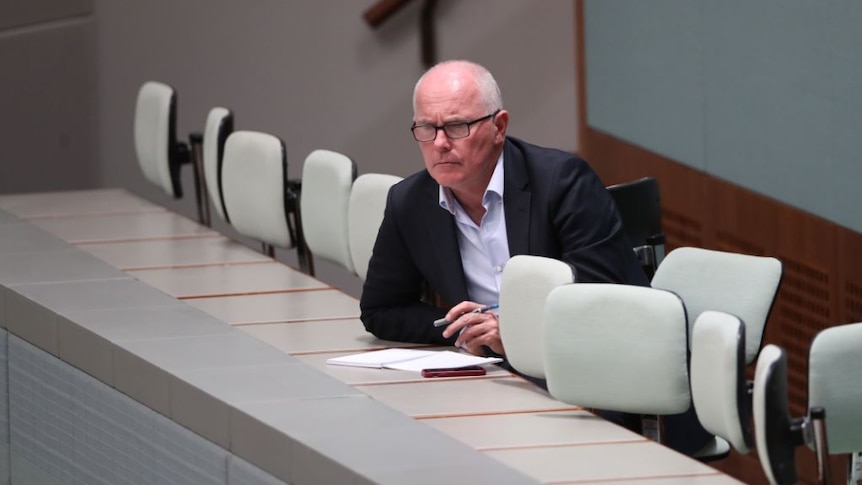 Michael Gordon sits behind a desk with a notebook and pen.