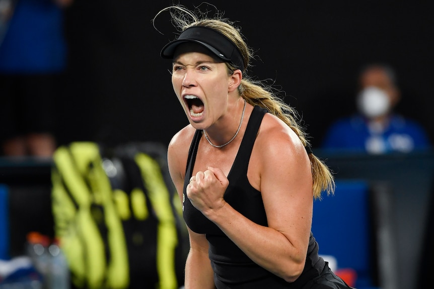 Tennis player Danielle Collins, wearing a black visor and dress, shouts and clenches her fist during the Australian Open final.
