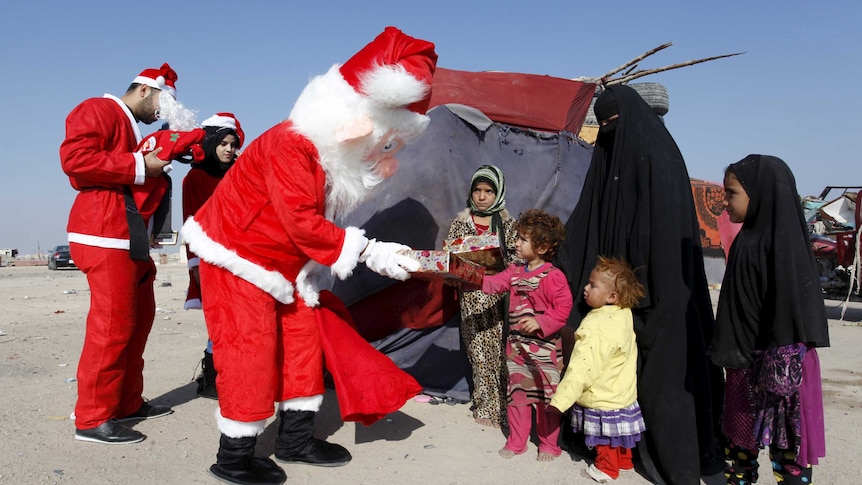 Santas distribute presents to Iraqi children