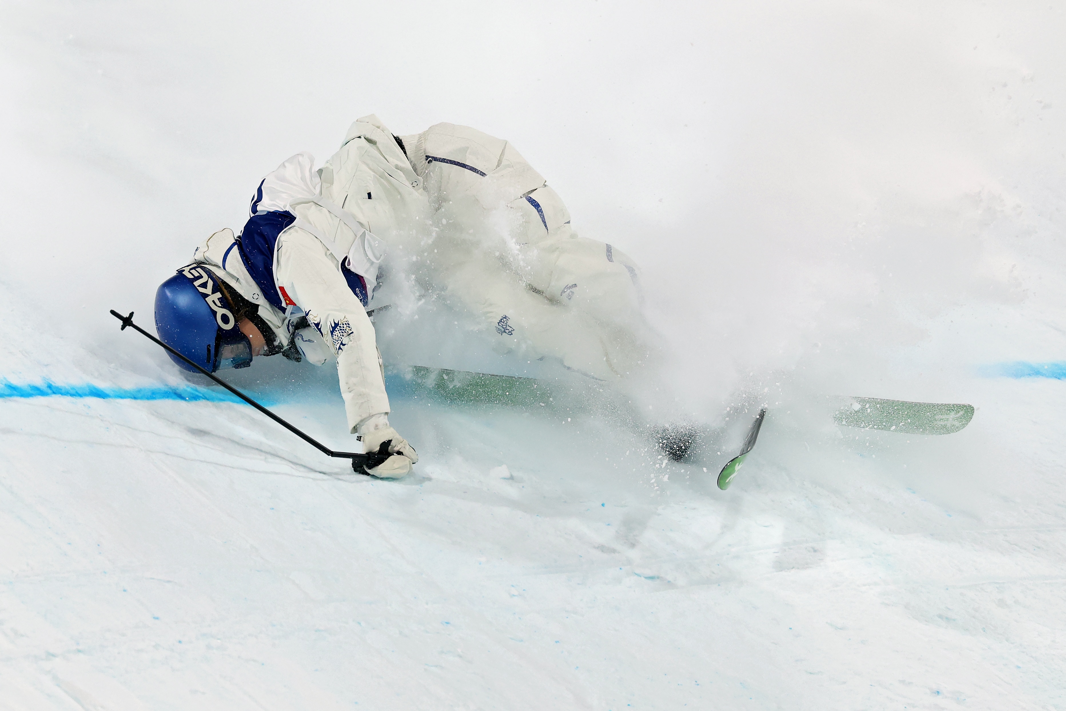 Eileen Gu atinge a neve ao cair na grande qualificação aérea.
