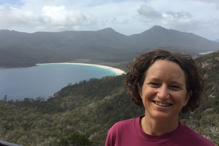 Caroline pictured on the coast wearing a pink top and her short curly hair out