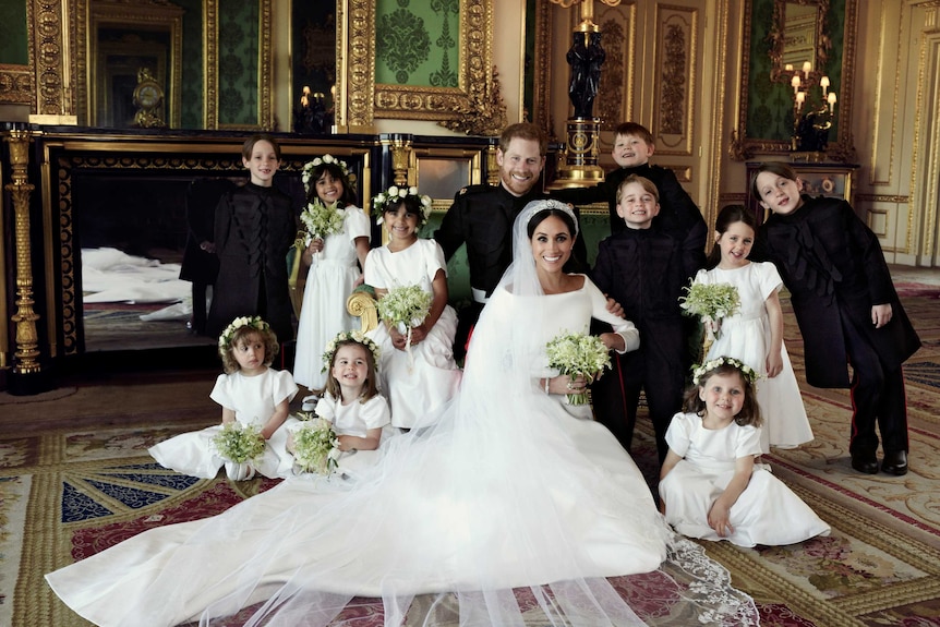 Meghan and Harry with the flower girls and page boys, including beaming a Prince George and Princess Charlotte.