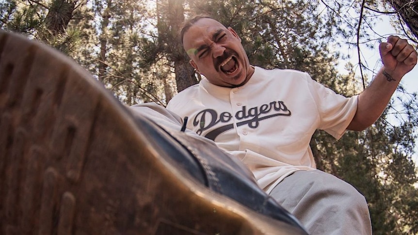 Dallas Woods in LA Dodgers baseball jersey and blue jeans stomping on camera