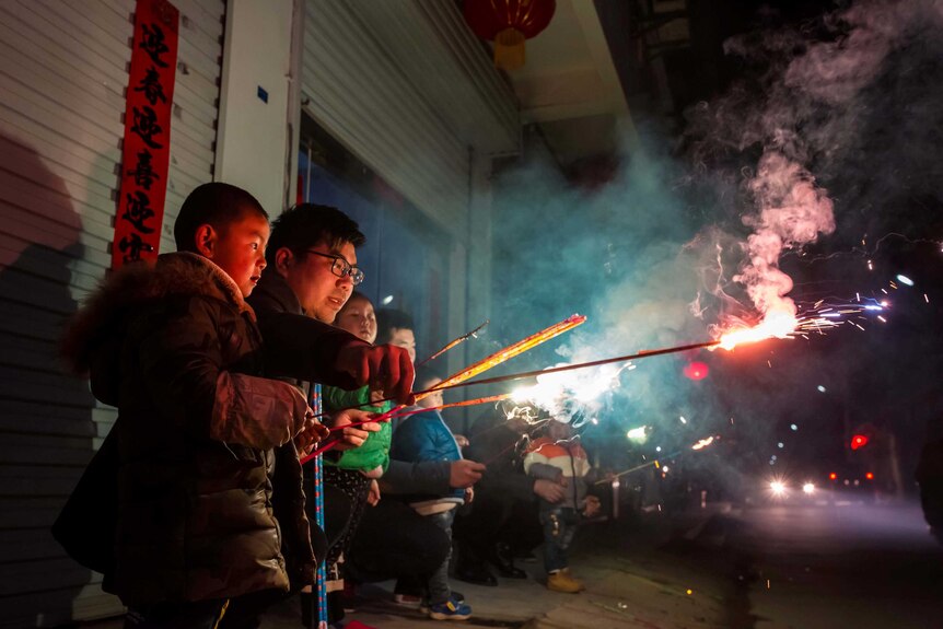 Children play with fire crackers on the eve of the Chinese Lunar New Year.